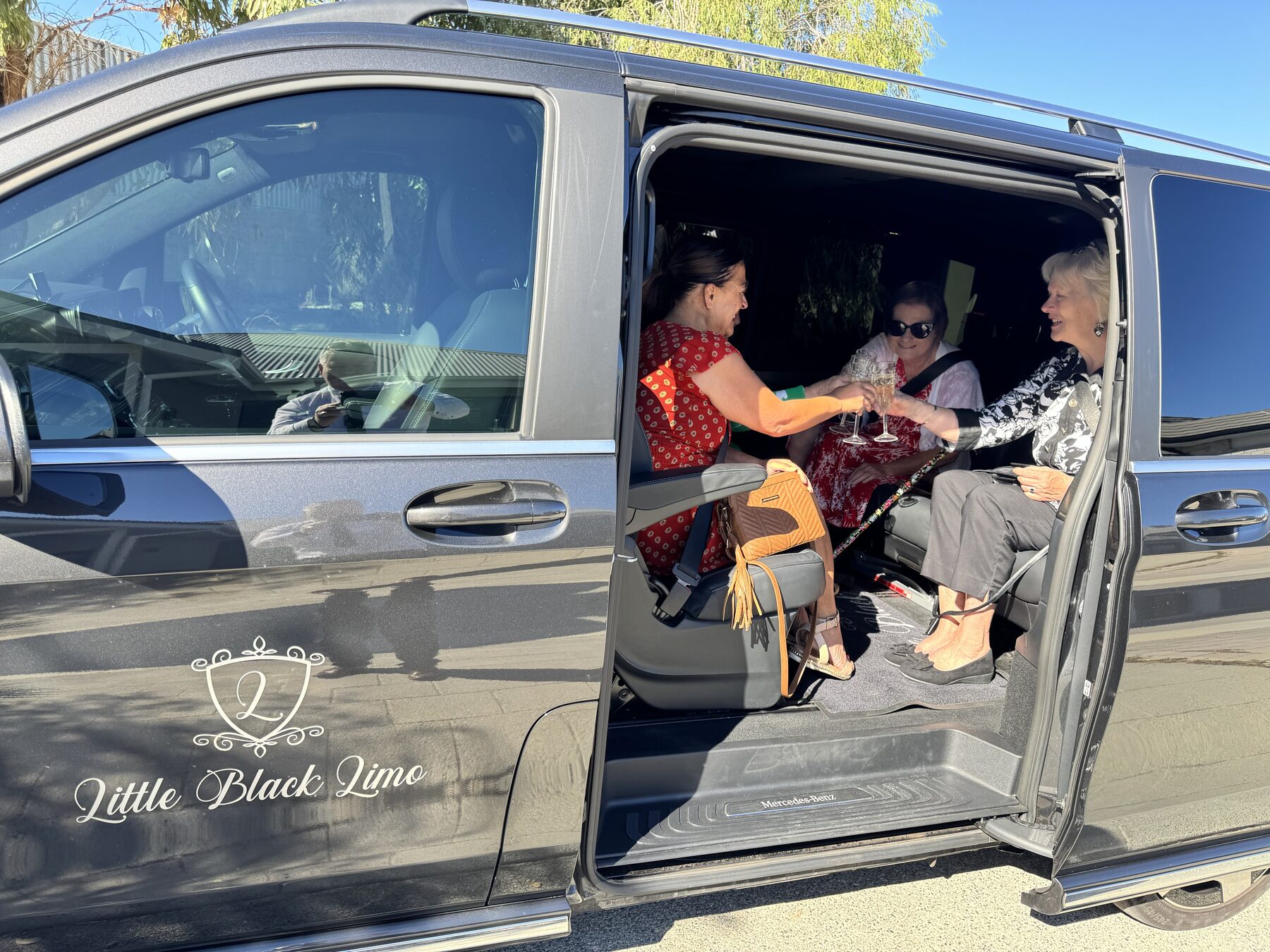 Guests toasting champagne in the van doorway