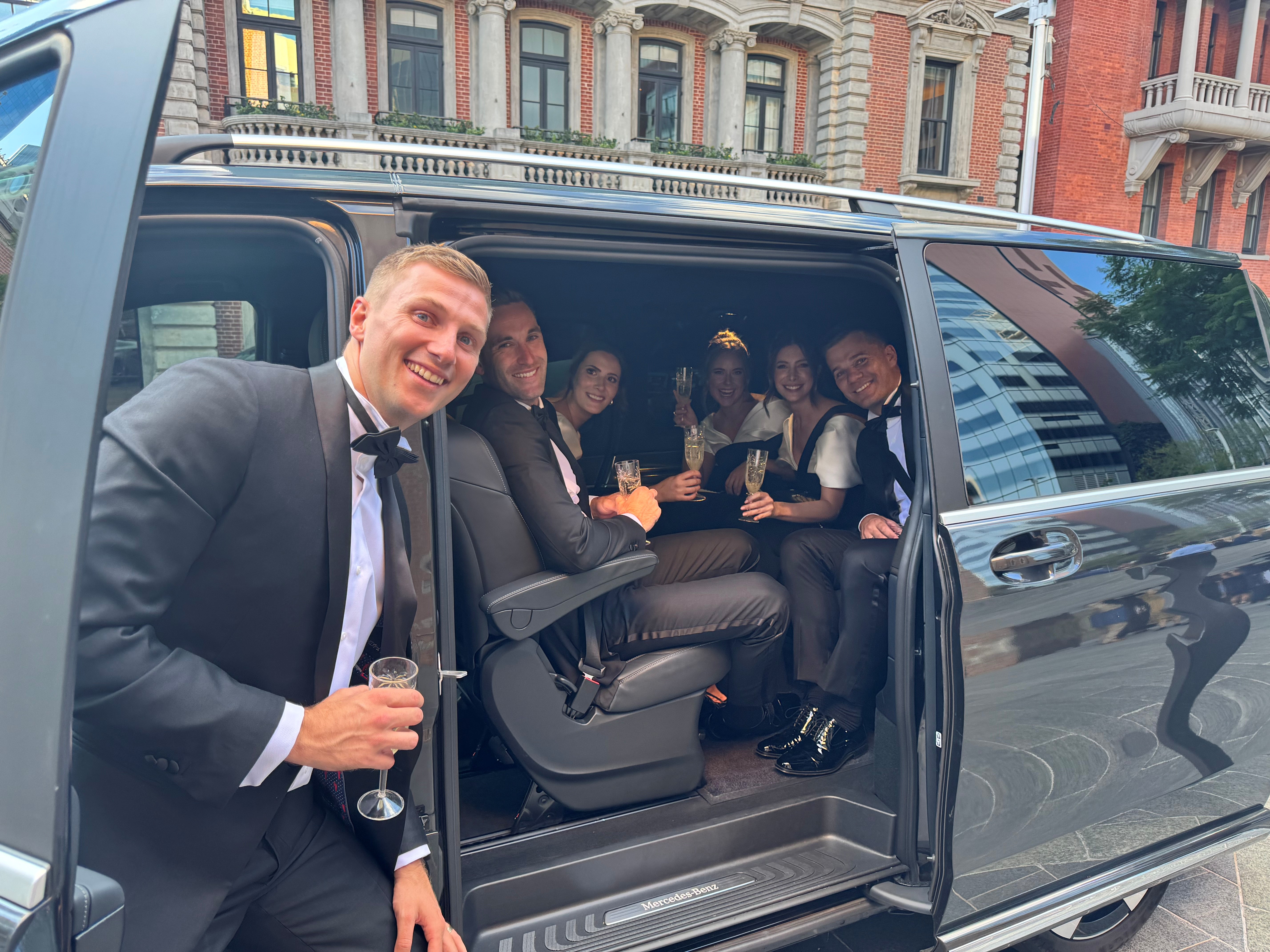 Bridal party beside the limo van